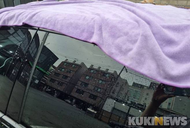 세차후 차를 마른 수건으로 닦는 모습