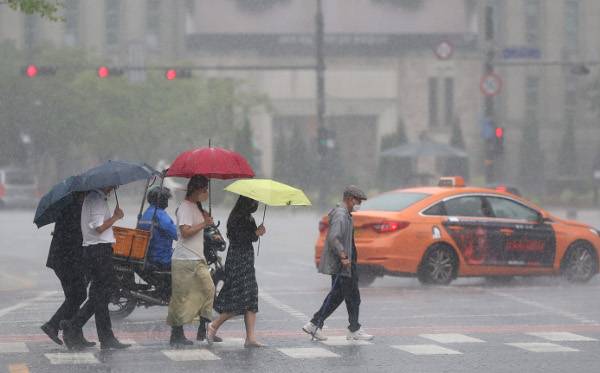 시민들이 29일 서울 중구 서울도서관 인근에서 폭우 속을 걸어가고 있다. 예년보다 빨리 시작된 장마에 교회마다 시설과 위생을 점검하고 소방계획을 마련해야 할 필요성이 커졌다. 연합뉴스