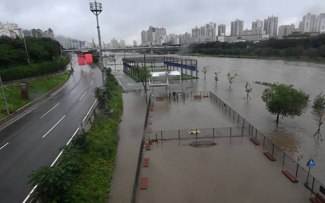 30일 오전 장맛비로 중랑천 수위가 상승해 서울 동부간선도로가 전면 통제된 가운데, 중랑교 인근 중랑천 둔치 운동시설이 물에 잠겨 있다.   신창섭 기자