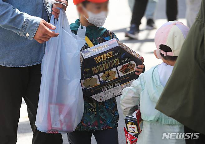 [서울=뉴시스] 권창회 기자 = 어린이날을 닷새 앞둔 1일 오전 서울 종로구 창신동 문구완구거리에서 아이가 장난감을 들고 이동하고 있다. 2022.05.01. kch0523@newsis.com