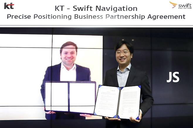 서울 송파구 KT 송파빌딩에서 KT AI 모빌리티사업단장 최강림 상무가(오른쪽) 스위프트 내비게이션 CEO 티모시 해리스(화면)와 함께 비대면으로 사업계약 체결 후 기념 촬영을 하고 있다. 