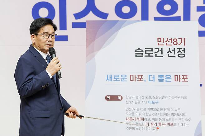박강수 서울 마포구청장 당선인이 지난 29일 마포중앙도서관에서 열린 ‘민선 8기 마포구청장직인수위원회 해단식’에서 새 구정 슬로건 ‘새로운 마포, 더 좋은 마포’를 선포하고, 선정 배경을 설명하고 있다.민선 8기 마포구청장직인수위원회 제공