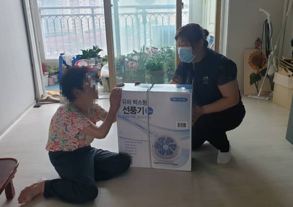 기후변화 진단상담사가 기후위기 가구를 방문해 선풍기를 전달하는 모습 ⓒ김해시