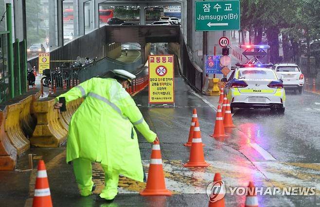 한강 잠수교 차량 통제 (서울=연합뉴스) 홍해인 기자 = 밤사이 장맛비가 지속되며 한강 홍수 조절 기능을 하는 팔당댐 일부 수문이 개방된 30일 오전 6.2m에 도달한 서울 잠수교 북단에서 경찰이 한강 수위 상승으로 차량 출입을 통제하고 있다. 2022.6.30 hihong@yna.co.kr