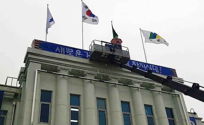 집중호우 속에 긴급 교체되는 새 강원 도정 구호  30일 최문순 도정 구호를 담은 강원도청사 현관의 간판 위에 김진태 당선인의 새 도정 구호인 '새로운 강원도! 특별자치시대!' 현수막을 설치하는 작업이 집중 호우 속에 진행되고 있다. [촬영 이해용]