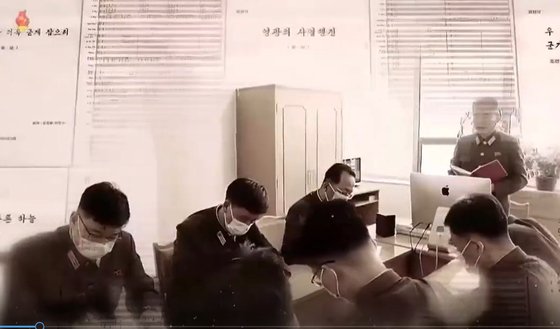 북한이 지난 4월 25일 진행한 열병식과 관련해 제작한 기록영화 속에 애플컴퓨터가 등장했다. 열병식 관계자들이 사무실에서 회의를 진행하고 있다. [조선중앙TV촬영]