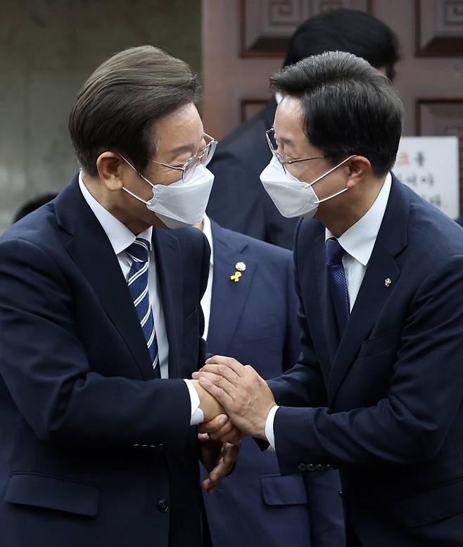 이재명  더불어민주당 의원과 당대표 출마를 선언한 강병원 의원이 30일 국회에서 열린 의원총회에 참석하며 악수하고 있다. 국회사진기자단