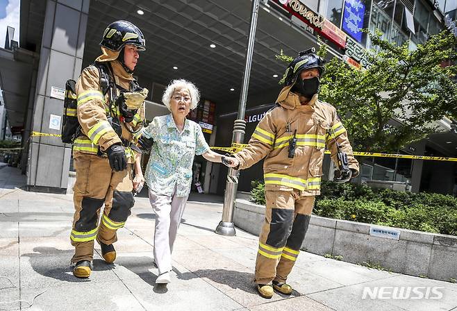 [서울=뉴시스] 정병혁 기자 = 1일 오전 서울 종로구 르메이에르 빌딩에서 원인을 알 수 없는 흔들림이 발생해 출동한 소방대원들이 한 입주민을 대피시키고 있다. 2022.07.01. jhope@newsis.com