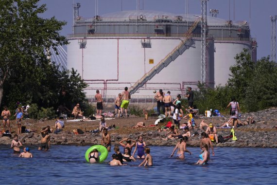 지난달 25일(현지시간) 러시아 상트페테르부르크의 유류 저장 탱크 부근에서 시민들이 해수욕을 즐기고 있다.AP뉴시스