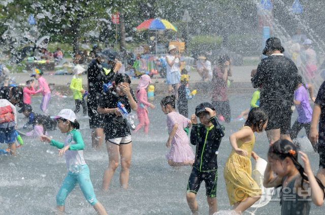 서울의 낮기온이 33도까지 오르며 무더위가 이어지고 있는 3일 서울 영등포구 여의도한강공원 물빛광장을 찾은 시민들이  물놀이를 하고 있다.