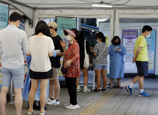 코로나19 확진자수가 0시 기준 1만59명을 기록한 3일 서울 용산구보건소 선별진료소를 찾은 시민들이 검사를 받기 위해 대기하고 있다. 뉴시스