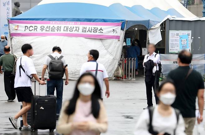 [서울=뉴시스] = 코로나19 신규 확진자가 1만463명으로 집계된 29일 오전 서울 중구 서울역에 마련된 임시선별검사소 앞을 시민들이 오가고 있다. 2022.06.29.