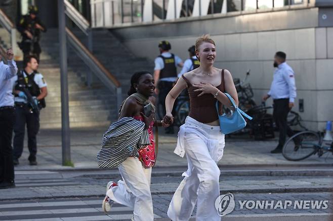 코펜하겐 쇼핑몰에서 총격 사건 발생 (AFP=연합뉴스) 3일(현지시간) 덴마크 수도 코펜하겐에 있는 쇼핑몰인 필즈몰에서 총격 사건이 발생했다. 경찰이 대피시키고 있는 가운데 사람들이 피신하고 있다. 2022.7.4 photo@yna.co.kr