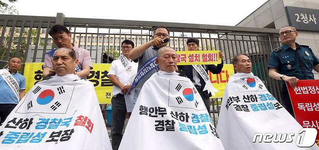 전국경찰직장협의회(직협) 소속 장유석 청주상당경찰서 직협회장, 윤홍선 인천삼산경찰서 직협 회장, 경남청 김건표 경위가 5일 오전 정부세종2청사 행정안전부 앞에서 경찰국 신설 정책 철회를 요구하는 호소문을 발표한 뒤 릴레이 삭발을 진행하고 있다. 2022.7.5/뉴스1 © News1 김기남 기자