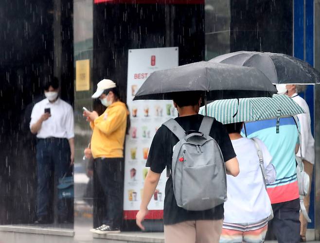 소나기가 쏟아진 지난 4일 오후 서울 중구 한 거리에서 시민들이 우산을 쓰고 걸어가고 있다. 뉴시스