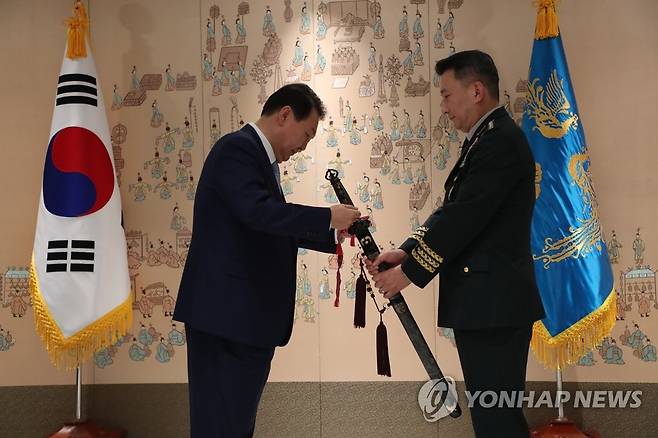 삼정검에 수치 달아주는 윤석열 대통령 (서울=연합뉴스) 안정원 기자 = 윤석열 대통령이 5일 서울 용산 대통령실 청사에서 열린 신임 합참의장 삼정검 수치 수여식에서 김승겸 합참의장의 삼정검에 수치를 달아주고 있다. 2022.7.5 [대통령실통신사진기자단] jeong@yna.co.kr