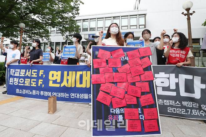 연세대 청소경비노동자 투쟁 관련 재학생 기자회견이 6일 오전 연세대학교 신촌캠퍼스 백양관 앞에서 열린 가운데 연세대 판넬에 스티커를 부착하고 있다. (사진=이영훈 기자)