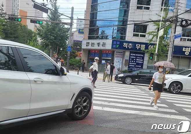 경찰이 6일 전북 전주시 중화산동의 한 사거리에서 12일부터 시행되는 개정 도로교통법 '보행자 보호의무 강화' 관련 지도·안내 활동을 벌이고 있다.2022.7.6/© 뉴스1 강교현기자