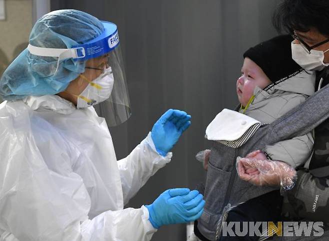 용산구 보건소 선별진료소에서 어린 아기를 안은 가족이 코로나19 검사를 받고 있다.  쿠키뉴스DB