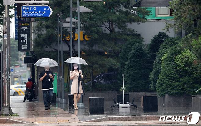 서울 도심에 소나기가 내린 4일 서울 명동거리에서 우산을 쓴 시민들이 발걸음을 옮기고 있다. 2022.7.4/뉴스1 © News1 박세연 기자