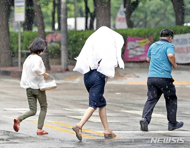 [서울=뉴시스] 김금보 기자 = 소나기가 내린 지난 4일 오후 서울 영등포구 거리에서 시민들이 비를 피해 이동하고 있다. 2022.07.04. kgb@newsis.com