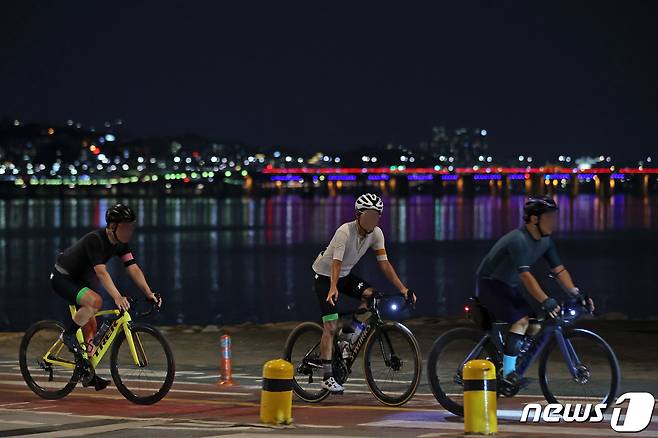 열대야가 이어진 6일 오후 서울 서초구 반포 한강공원에서 시민들이 자전거를 타고 있다. 7일은 저기압의 영향으로 전국 내륙에서 최대 150㎜ 이상 많은 비가 강하게 쏟아질 수 있으며, 장맛비에도 기온은 높게 유지되며 체감온도가 높아 무덥겠다. 2022.7.6/뉴스1 © News1 조태형 기자