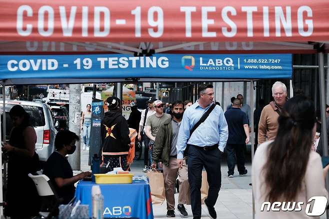 5월17일 미국 뉴욕 시민들이 코로나19 검사소 앞을 지나고 있다.  © AFP=뉴스1