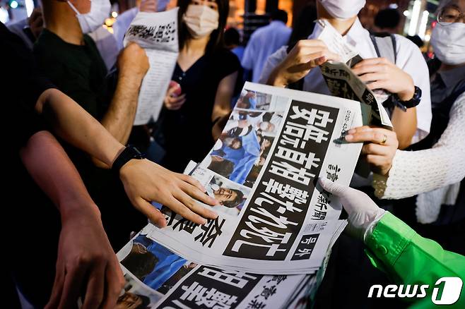 8일 일본 도쿄에서 아베 신조 전 총리의 사망을 보도하는 요미우리신문 특별판을 사람들이 받고 있다. © 로이터=뉴스1 © News1 임세영 기자