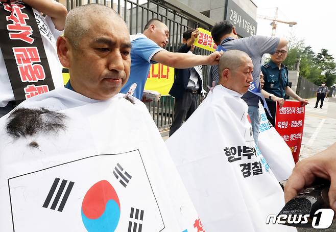 전국경찰직장협의회(직협) 소속 장유석 청주상당경찰서 직협회장과 윤홍선 인천삼산경찰서 직협 회장, 경남청 김건표 경위가 5일 오전 정부세종2청사 행정안전부 앞에서 경찰국 신설 정책 철회를 요구하는 호소문을 발표한 뒤 릴레이 삭발을 진행하고 있다. 2022.7.5/뉴스1 © News1 김기남 기자