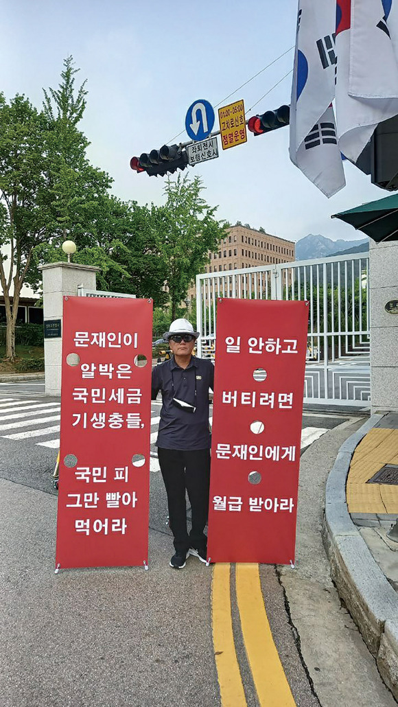 7월6일 과천 정부청사 정문 앞에서 1인 시위자가 문재인 정부 시절 알박기 인사들의 사퇴를 요구하는 선전물을 들 고 있다.ⓒ염순태 제공