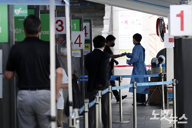 코로나19 신규 확진자가 사흘째 1만 명대를 기록한 7일 서울 용산구보건소 선별진료소에서 의료진이 시민들의 검사를 돕고 있다. 박종민 기자