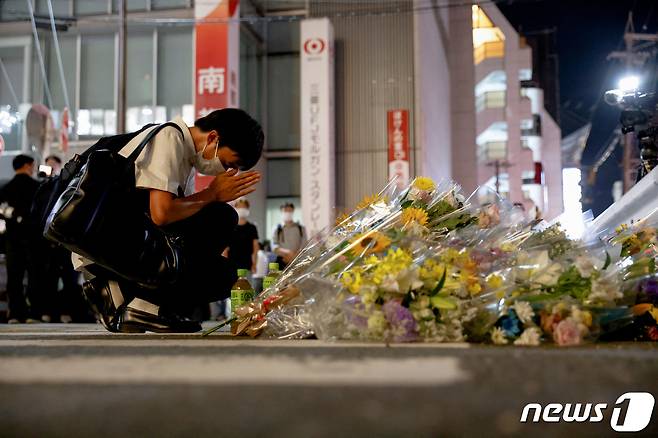 8일 일본 서부 나라현 야마토사이다이지 인근에서 고 아베 신조 전 총리가 총선 유세 도중 총에 맞아 숨진 현장에서 한 시민이 헌화하고 있다. © 로이터=뉴스1 © News1 임세영 기자