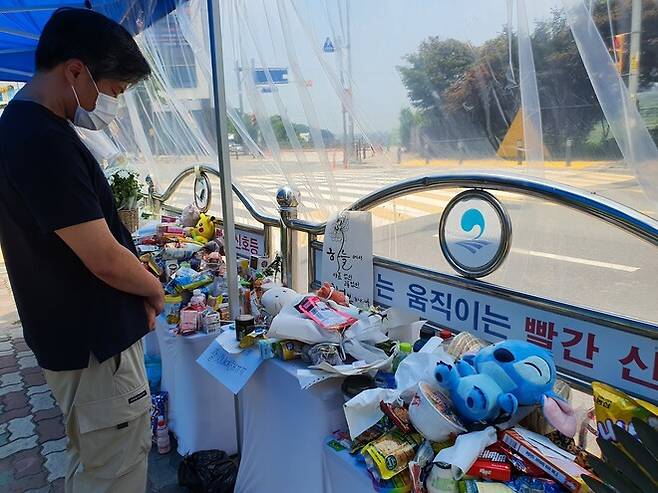 10일 오후 경기도 평택시 청북읍 한 초등학교 앞 횡단보도 한편에 마련된 추모공간을 방문한 40대 시민이 묵념하고 있다. 지난 7일 이 횡단보도를 건너던 이 초등학교 5학년 여학생이 신호를 위반하고 달리던 굴착기에 치여 숨졌다. 이정하 기자