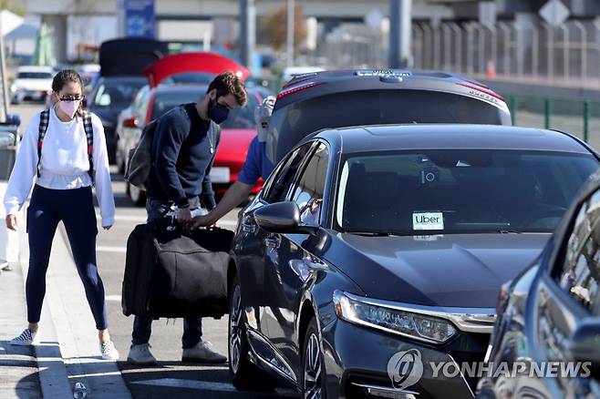 글로벌 확장을 위해 불법적 전략 구사한 우버 (로스앤젤레스 로이터=연합뉴스) 10일(현지시간) 미국 캘리포니아주 로스앤젤레스 국제공항에서 승객들이 우버 차량을 기다리고 있다. 이날 영국 일간 가디언과 AFP통신 등은 우버가 과거 글로벌 사업을 확장하기 위해 수사를 불법적으로 방해하고 정치권에 로비를 벌이는 등 불법적 전략을 구사했다고 보도했다. 2022.07.11 ddy04002@yna.co.kr