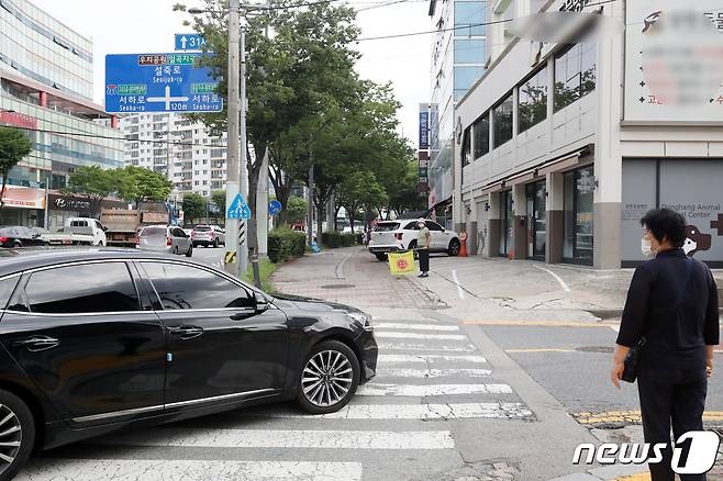 횡단보도 앞 일시 정지 의무를 확대하는 도로교통법 개정안 시행 첫날인 12일 오전 광주 북구 설죽로 인근 어린이보호구역에서 보행자가 횡단보도를 건너려는 상황에 차량이 먼저 진입해 지나가고 있다. 2022.7.12/뉴스1 © News1 이승현 수습기자