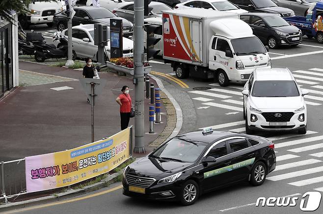 횡단보도 앞 일시정지 등 보행자 보호 의무를 강화한 도로교통법 개정안 시행 첫날인 12일 오전 울산 남구 한 교차로에서 우회전 차량이 보행자가 있지만 멈추지 않고 횡단보도를 지나고 있다. 2022.7.12/뉴스1 © News1 윤일지 기자