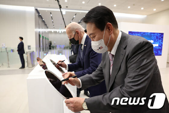 윤석열 대통령과 조 바이든 미국 대통령이 지난 5월 20일 경기 평택시 삼성전자 반도체 공장에서 만나 웨이퍼에 서명하고 있다. 이 웨이퍼는 삼성전자가 세계 최초로 양산하는 3나노미터(nm·10억 분의 1m) 공정 웨이퍼다.(사진=대통령실사진기자단, 뉴스1)