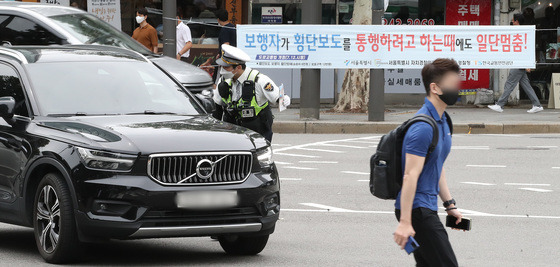 횡단보도 앞 일시정지 등 보행자 보호 의무를 강화한 도로교통법 개정안 시행 첫날인 12일 서울 종로구 이화사거리에서 경찰들이 계도에 나서고 있다. /사진=뉴스1