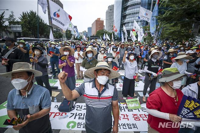 [서울=뉴시스] 정병혁 기자 = 농민의 길 관계자 및 참가자들이 12일 오후 서울 용산구 서울역 인근에서 열린 농어업홀대 윤석열 정부 규탄, 농어민생존권 쟁취, CPTPP가입 저지 7.12범국민 대회에서 구호를 외치고 있다. 2022.07.12. jhope@newsis.com