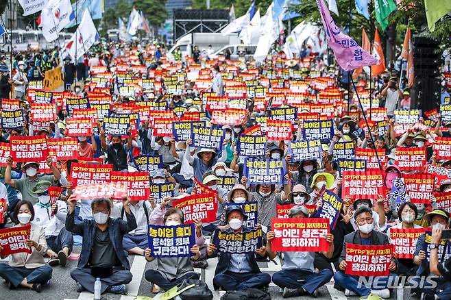 [서울=뉴시스] 정병혁 기자 = 농민의 길 관계자 및 참가자들이 12일 오후 서울 용산구 서울역 인근에서 열린 농어업홀대 윤석열 정부 규탄, 농어민생존권 쟁취, CPTPP가입 저지 7.12범국민 대회에서 구호를 외치고 있다. 2022.07.12. jhope@newsis.com