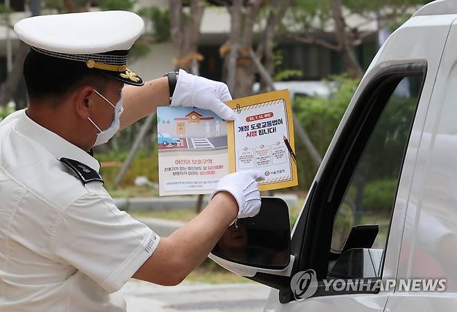 '횡단보도 보행자 보호' 개정 도로교통법 전면 시행 (서울=연합뉴스) 임헌정 기자 = '횡단보도 보행자 보호'를 골자로 하는 개정 도로교통법 시행 첫날인 12일 서울 송파구 해누리초등학교 앞 어린이보호구역에서 송파경찰서 경찰관이 계도 활동을 하고 있다. 2022.7.12 kane@yna.co.kr