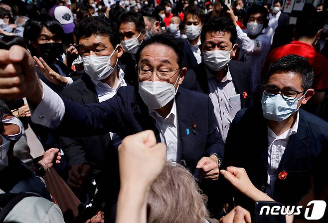 일본 집권당 자민당 총재인 기시다 후미오 일본 총리가 도쿄 남쪽 가와사키에서 참의원 선거연설을 한 뒤 유권자들과 주먹다짐하는 모습. © 로이터=뉴스1 © News1 이서영 기자