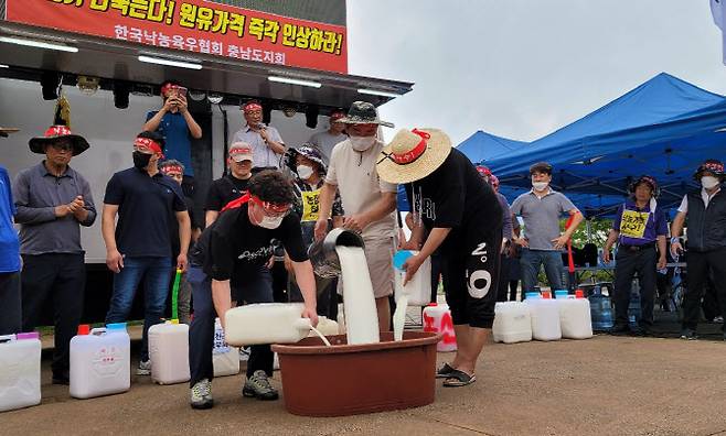 낙농협회 충남도지회에 속한 낙농민들이 지난 11일 충남도청 앞에서 열린 ‘낙농 말살 정부·유업체 규탄’ 궐기대회에서 원유를 쏟아버리고 있다.(사진=연합뉴스)