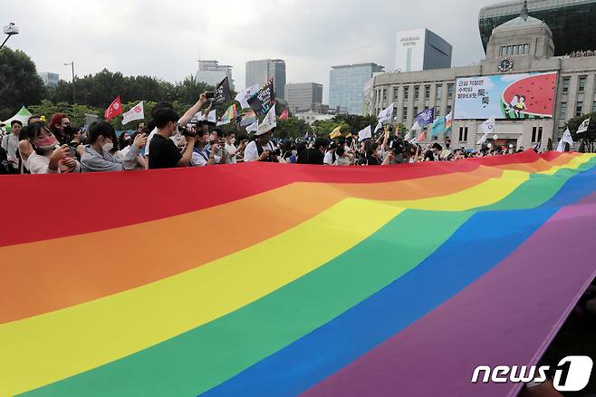 16일 서울광장에서 열린 서울퀴어문화축제를 찾은 시민들이 무지개 깃발이 펼쳐지자 환호하고 있다. 2022.7.16/뉴스1 © News1 조태형 기자