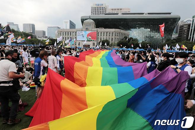 16일 서울광장에서 열린 서울퀴어문화축제를 찾은 시민들이 무지개 깃발이 펼쳐지자 환호하고 있다. 2022.7.16/뉴스1 © News1 조태형 기자