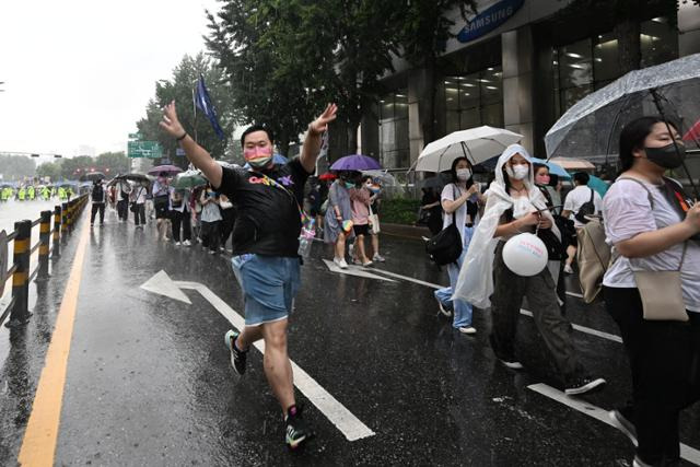 퀴어문화축제 행진이 진행되는 중에 한 참가자가 빗속을 뛰어가며 행복한 표정을 짓고 있다. 최주연 기자