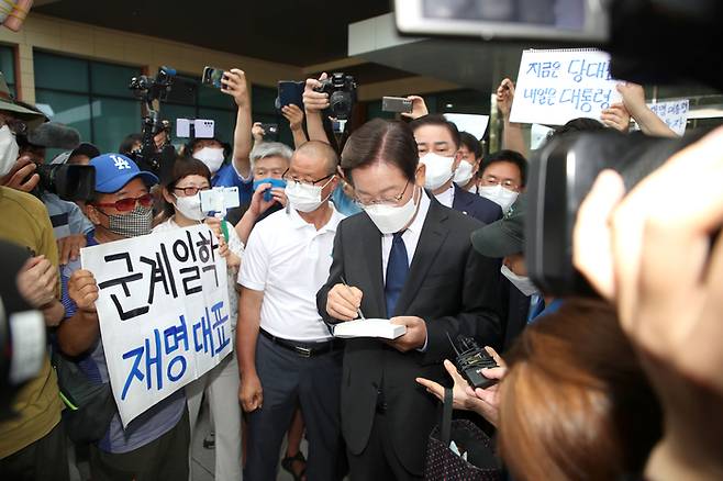 이재명 더불어민주당 의원이 17일 국회에서 당대표 출마 기자회견을 마친 뒤 회견장을 나서며 지지자에게 사인해 주고 있다. 국회사진기자단