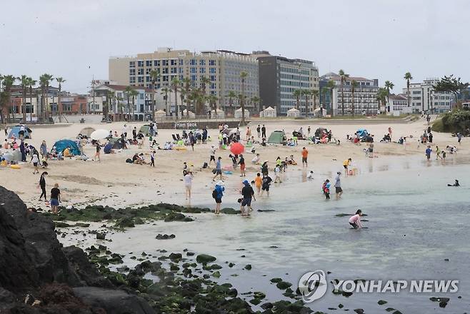 함덕해수욕장 찾은 나들이객 (제주=연합뉴스) 백나용 기자 = 12일 오후 제주시 조천읍 함덕해수욕장을 찾은 나들이객이 해수욕하면서 주말을 보내고 있다. 2022.6.12 dragon.me@yna.co.kr