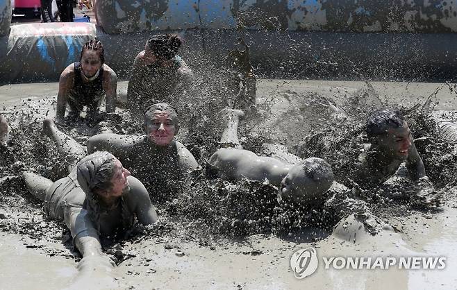 머드 체험으로 무더위 '싹' (보령=연합뉴스) 강수환 기자 = 서해안권 첫 해양 국제행사인 '2022 보령 해양머드박람회'와 제25회 보령 머드축제가 열린 17일 오후 충남 보령 대천해수욕장 일대에서 입장객들이 신나는 머드 체험을 하고 있다. 2022.7.17 swan@yna.co.kr