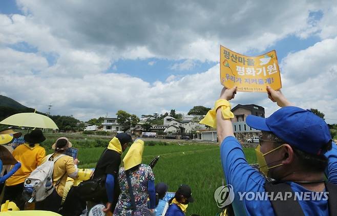 우리가 지킨다 (양산=연합뉴스) 이정훈 기자 = 전국에서 온 문재인 전 대통령 지지자들이 17일 낮 문재인 전 대통령 사저가 있는 경남 양산시 하북면 지산리 평산마을에 모여 평산마을 평온 회복과 문 전 대통령 부부 안녕을 기원하는 집회를 했다. 한 집회 참석자가 사저를 향해 평산마을 평온을 기원하는 글이 적힌 피켓을 들고 있다. 2022.7.17 seaman@yna.co.kr